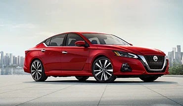 2023 Nissan Altima in red with city in background illustrating last year's 2022 model in Nissan of St. Augustine in St. Augustine FL